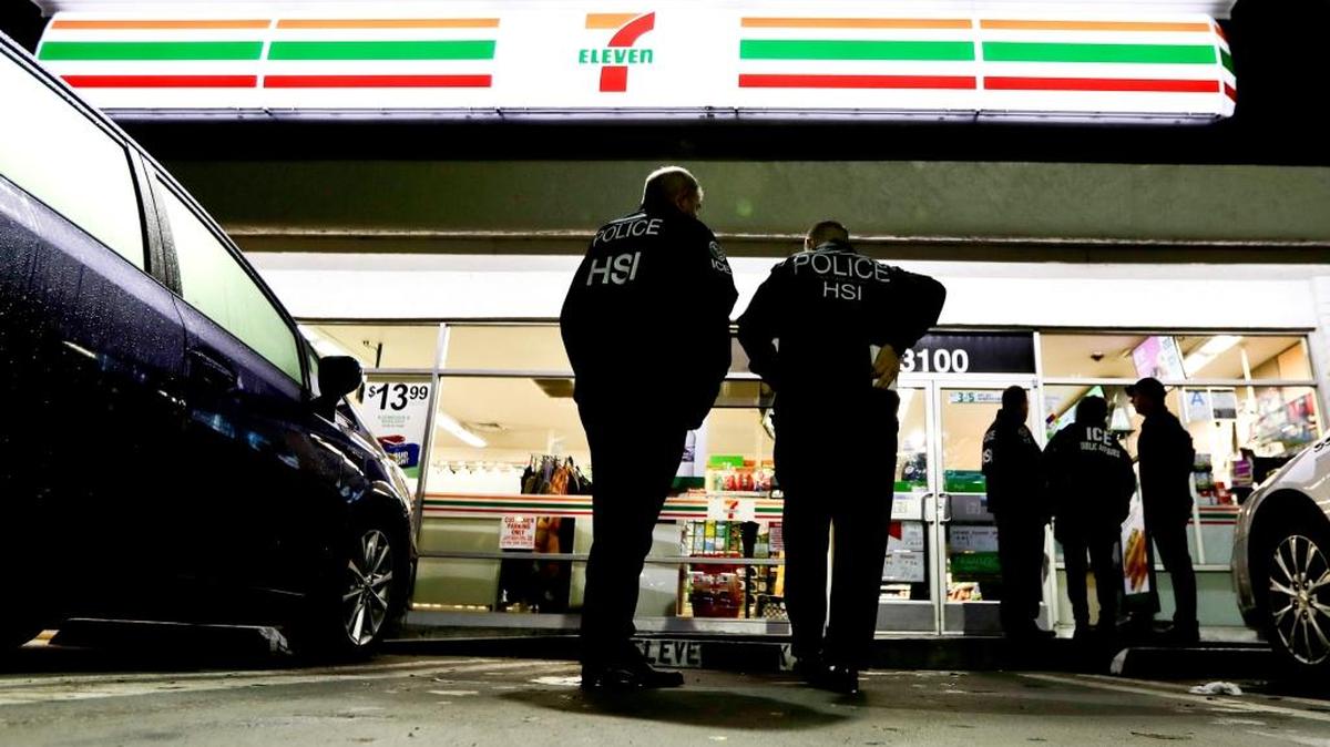 U.S. Immigration and Customs Enforcement agents serve an employment audit notice at a 7-Eleven convenience store Wednesday in Los Angeles. Agents said they targeted about 100 7-Eleven stores nationwide Wednesday to open employment audits and interview workers.