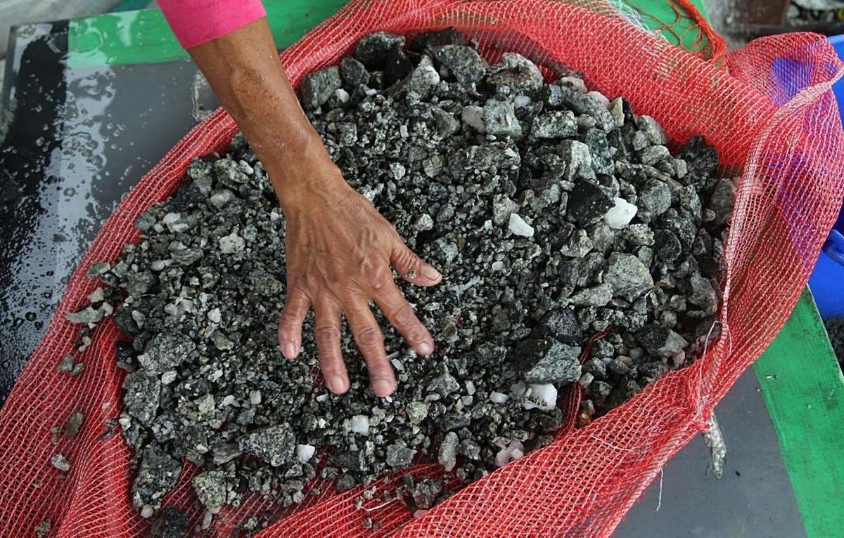 Doris Fonegra, one of a group of workers — mostly women — called chatarreros, reaches into a pile of rocks, looking to sort out those containing particles of gold extracted from Las Brisas independent gold mine, located in the town of Segovia, in Colombia’s Antioquia department, on Monday May 08, 2017.