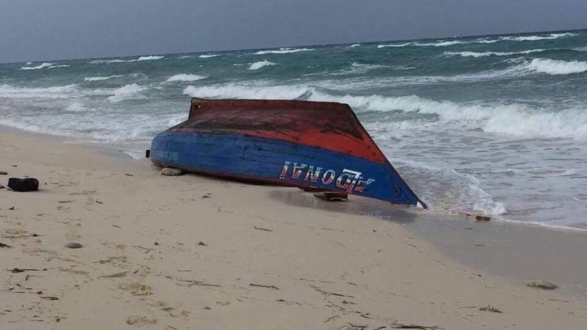 A boat painted in the colors of the Haitian flag was seen capsized on a beach in Providenciales in the Turks and Caicos Islands on Tuesday morning where 5 bodies washed ashore.