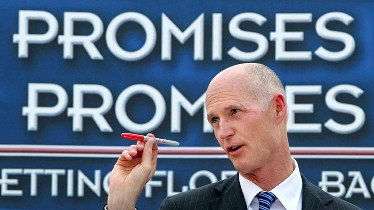Gov. Rick Scott waves a veto pen at The Villages in 2011.