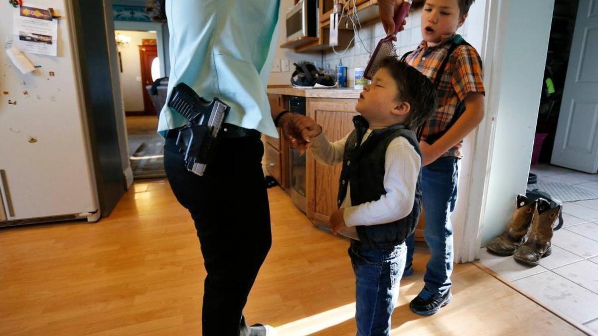 Gun-rights advocate, restaurant owner and mother of four sons, Lauren Boebert, wears her usual gun on her hip as she brushes the hair of Roman, 3, as the family gets ready to leave home for church in Rifle, Colo., on May 1, 2016.