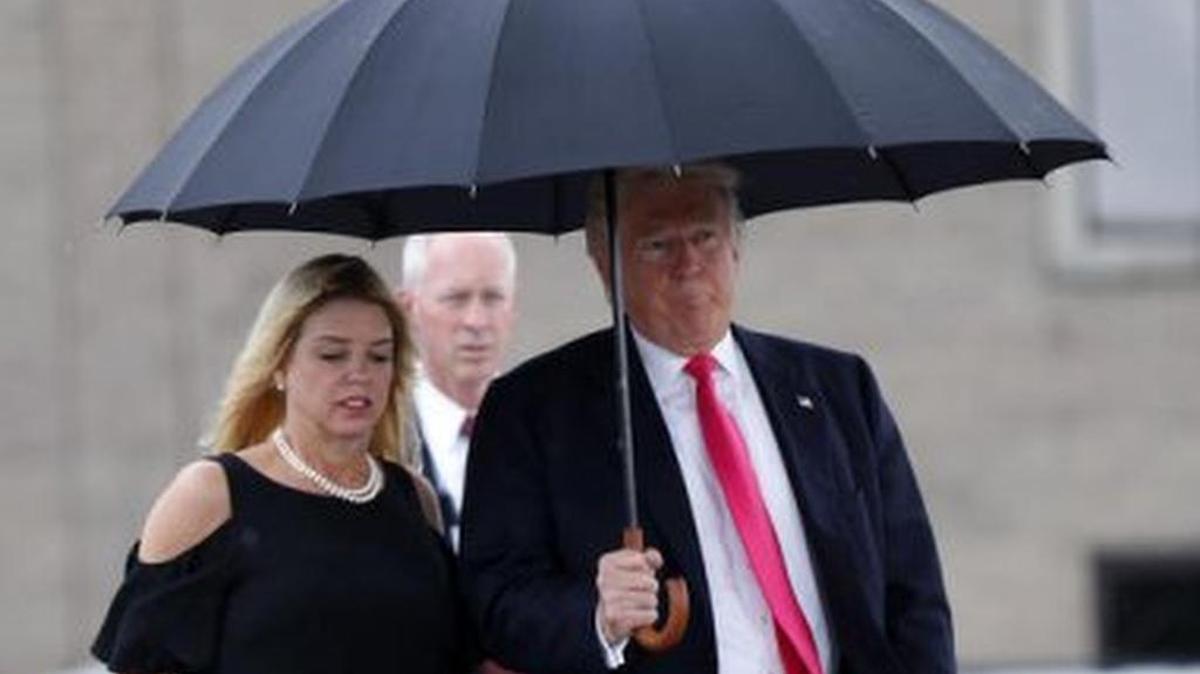 FILE PHOTO: President-elect Donald Trump walks in the rain with Florida Attorney General Pam Bondi, as they arrive at a campaign rally in Tampa, Wednesday, Aug. 24, 2016.
