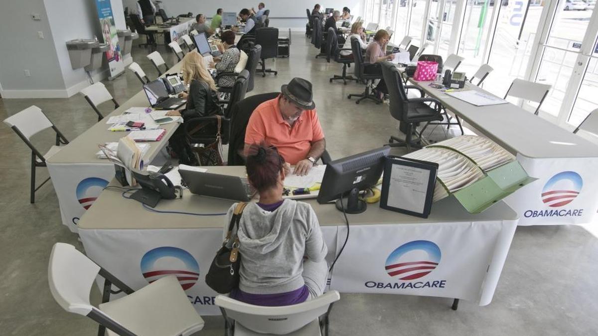 An insurance agent in Miami helps a consumer sign up for coverage through the Affordable Care Act exchange in this February 2015 photo. Health insurance companies underestimated the cost of covering the newly insured on the ACA exchange, leading to higher premiums and less choice for many consumers, according to a study released Thursday.