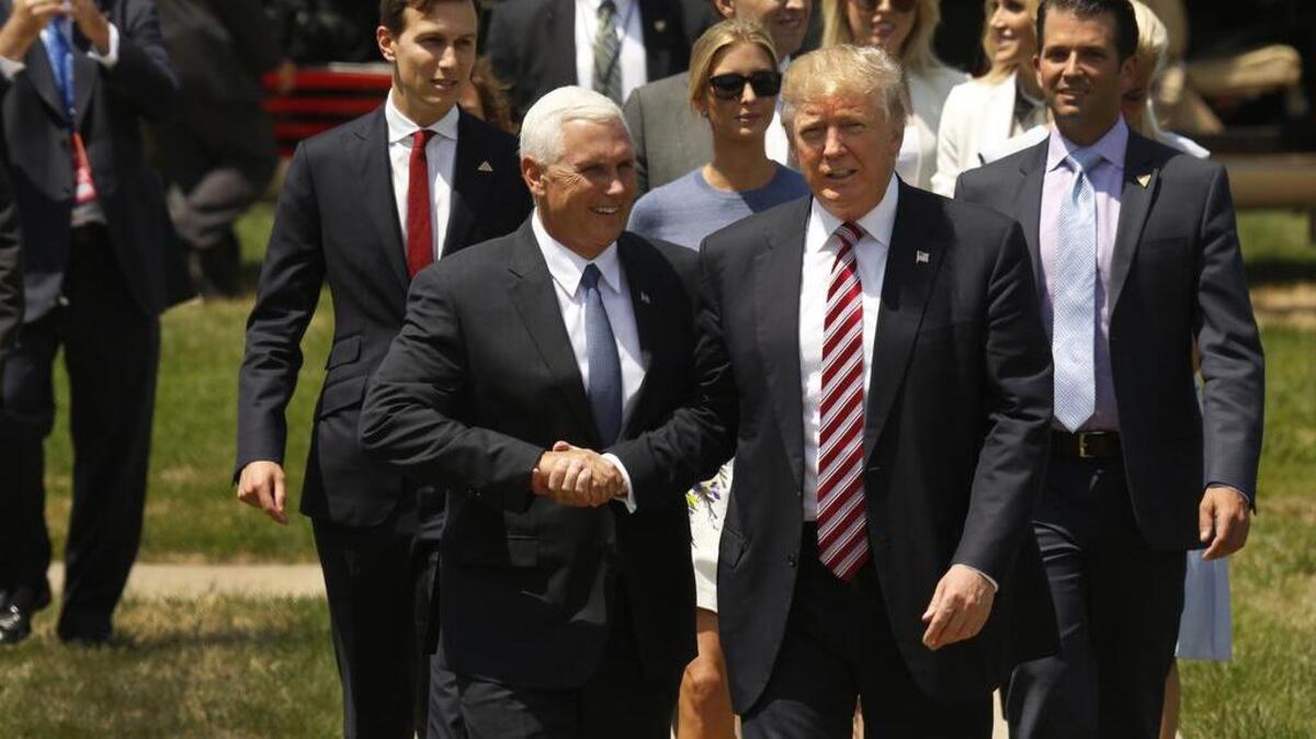 Republican presidential candidate Donald Trump is greeted by his running mate Mike Pence after arriving by helicopter at the Cleveland Science Center on Wednesday.