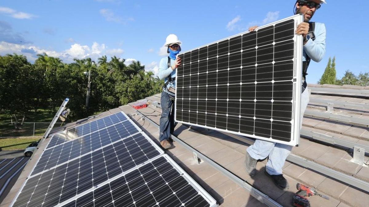 Martin Cabrera and Joseph Molina of Cutler Bay Solar Solutions install solar panels at a home in South Miami-Dade, November 13, 2015.
