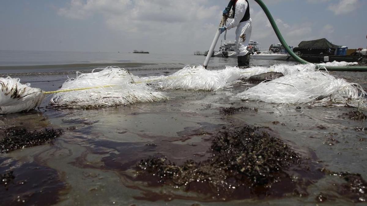 In this June 9, 2010 file photo, a worker uses a suction hose to remove oil washed ashore from the Deepwater Horizon spill, in Belle Terre, La. The Trump administration on Tuesday decided to exclude waters off the Florida coast from oil drill expansion.