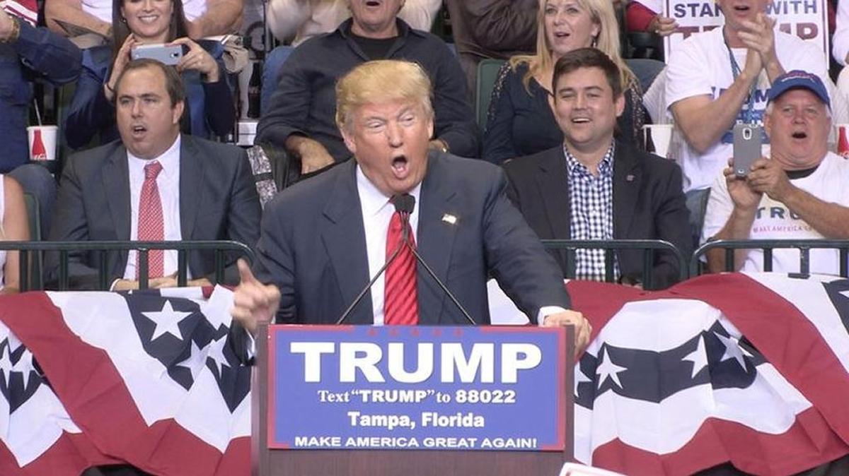 Sarasota Republican Party Chairman Joe Gruters (left) behind Donald Trump during a speech in Tampa on Feb. 12, 2016.