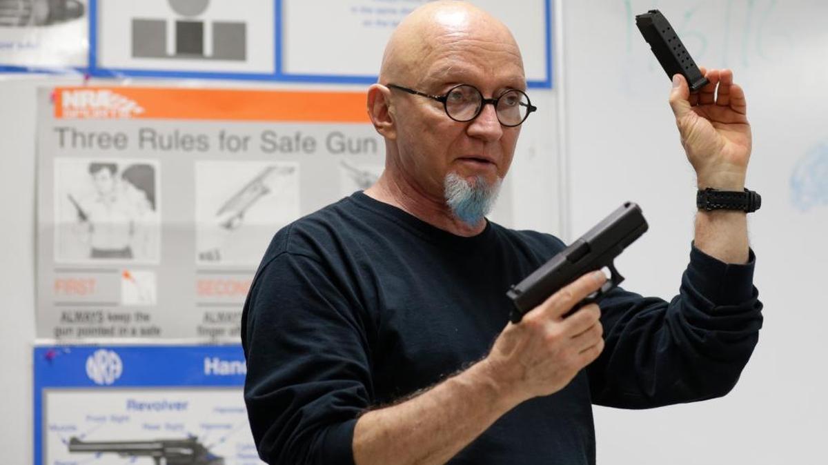 Mike Weinstein, director of training and security at the National Armory gun store and gun range, holds up a Glock 9mm hand gun during a Concealed Weapons Permit class, Tuesday, Jan. 5, 2016, in Pompano Beach.
