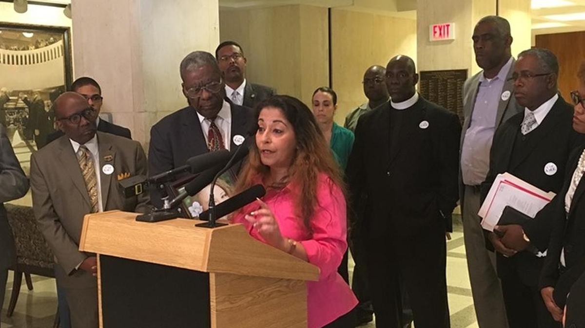 Darlene Farah, whose daughter Shelby was murdered in 2013, calls for an end to the death penalty surrounded by church leaders in the state Capitol on Tuesday.