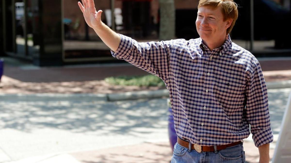 Agriculture commissioner Adam Putnam waves to motorists along Main Street, Tuesday, May 9, 2017, in Bartow.
