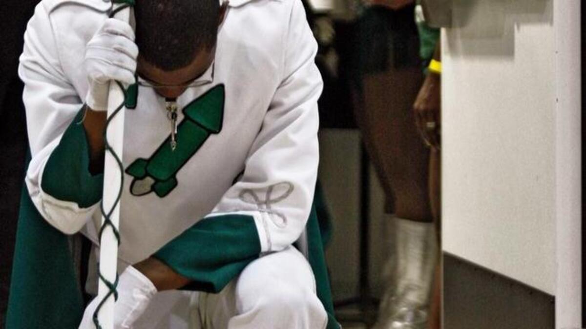 Drum Major Andre Young kneels in prayer in the doorway prior to performing with Miami Central High School band in May 2009. Lawmakers in Tallahassee want to fortify students’ and teachers’ rights to express their religious beliefs in Florida public schools.