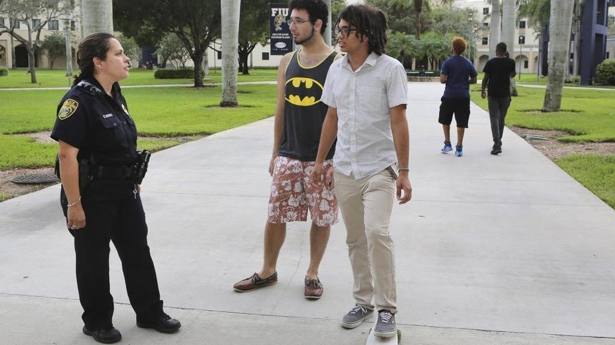 Florida International University Police officer Sonia Meneses, left, chats with FIU students Colin Lugo, center, and Christian Colevas in fall 2015 at FIU’s Modesto A. Maidique Campus in Miami.