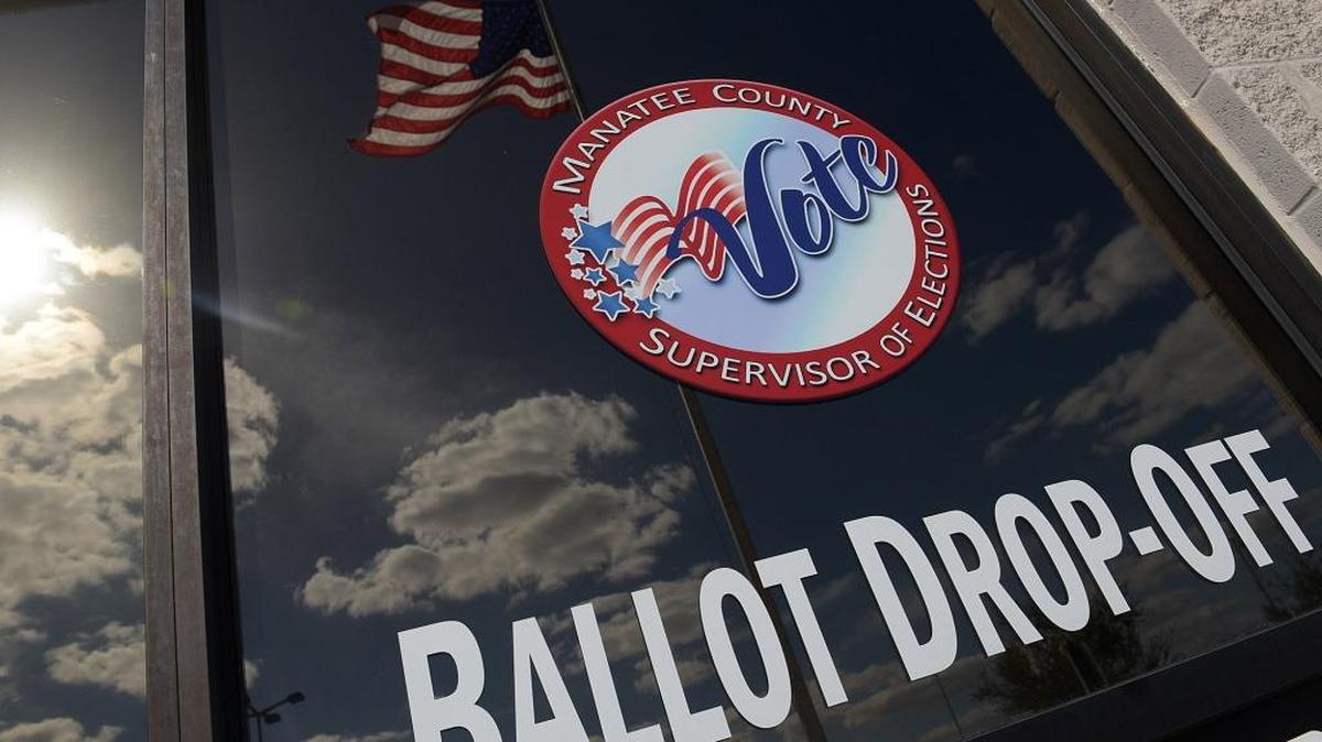 The American flag is reflected in the window of the Supervisor of Elections Office in Bradenton on Election Day 2016.
