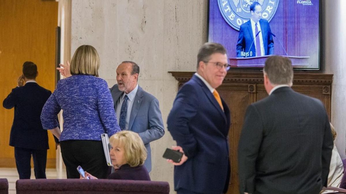Lobbyists work the fourth floor rotunda outside the House and Senate Chambers during the session at the Florida Capital in Tallahassee on Monday.