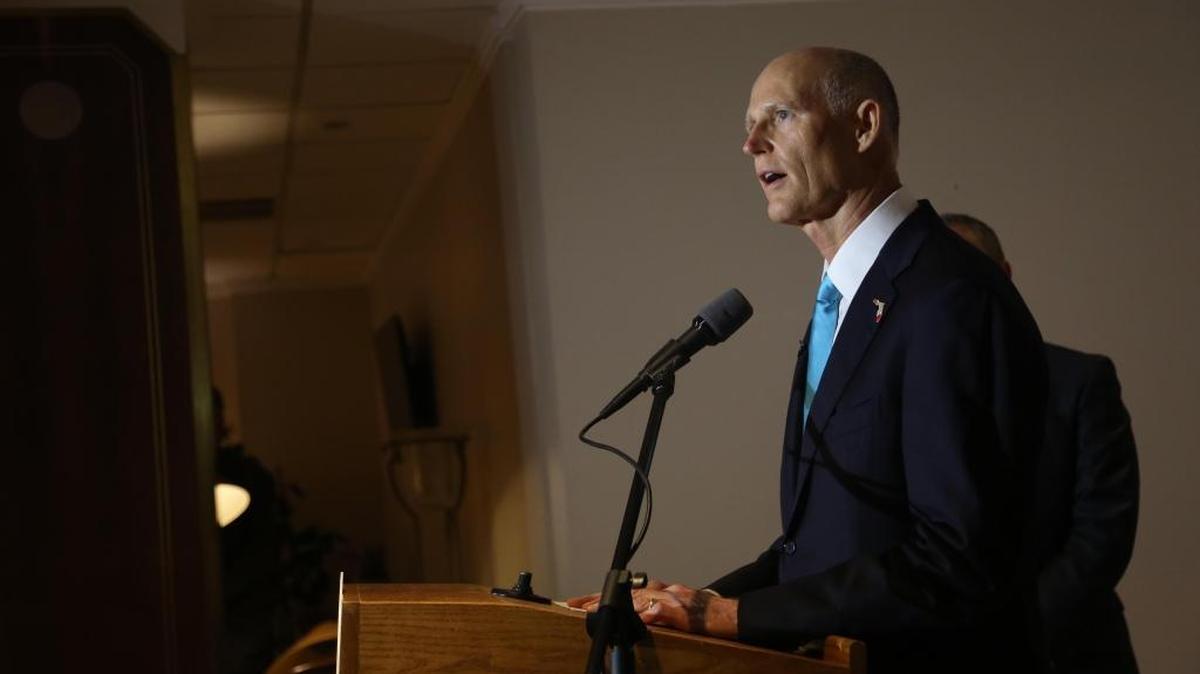 Gov. Rick Scott, center, speaks during a press conference at Miami International Airport on Friday, June 2, 2017.