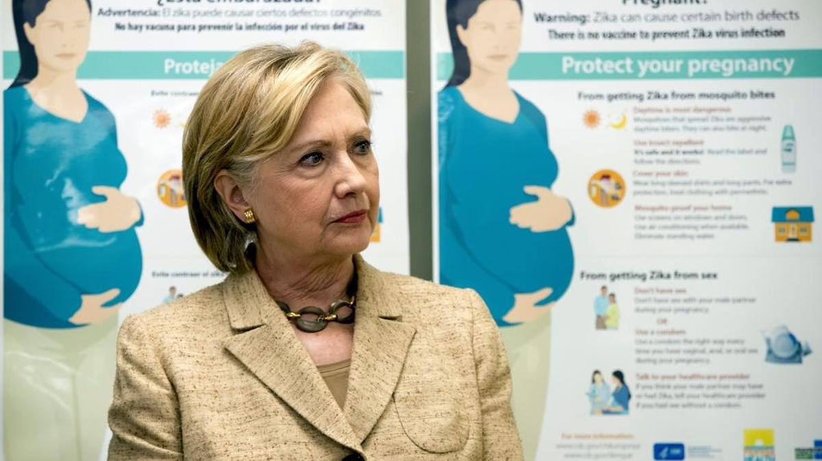 Informational Zika posters for pregnant woman are displayed behind Democratic presidential candidate Hillary Clinton as she takes a tour of Borinquen Health Care Center, in Miami on Tuesday.