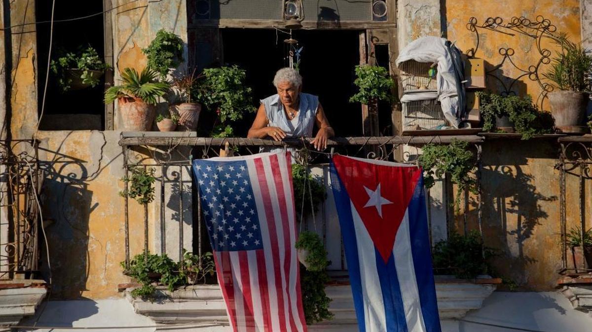 In this Dec. 19, 2014 file photo, Javier Yanez stands on his balcony decorated with U.S. and Cuban flags in Old Havana.