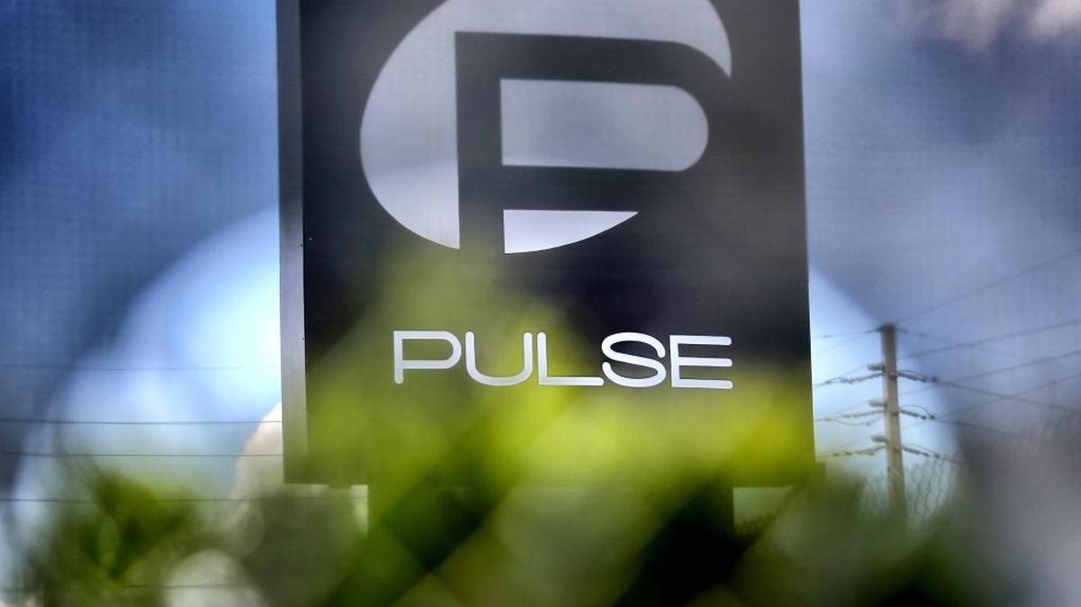 The sign for he Pulse nightclub, site of the largest mass shooting in modern U.S. history, is visible through a fence privacy screen that now surrounds the club in Orlando, Fla., Thursday, June 23, 2016.