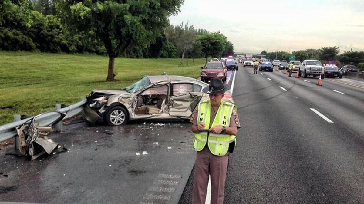 Florida Highway Patrol Sgt. Mark Wysocky investigates a deadly crash on the northbound Florida Turnpike at Mile Marker 71 near the Sawgrass Expressway, Sept. 23, 2013.
