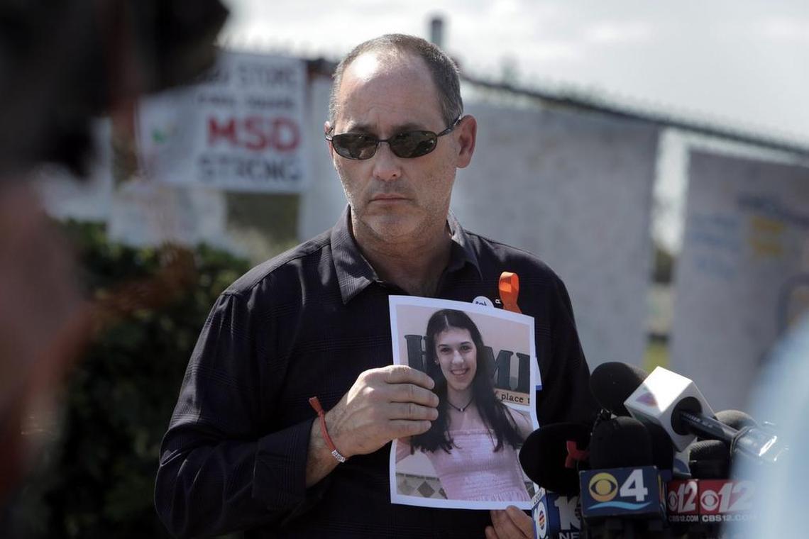 In this Miami Herald file photo, Fred Guttenberg, father of Jaime Guttenberg, who was killed in the Parkland massacre, holds a photo of Jaime as he listens to questions from reporters in front of Marjory Stoneman Douglas High School.