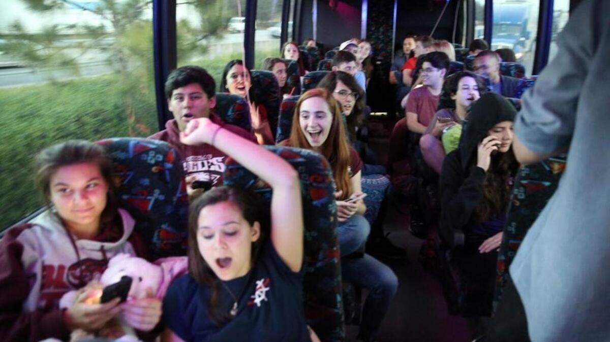 Stoneman Douglas students Lindsey and Julia Salomone (front row) and Jose Iglesias and Isabelle Robinson react to news that Oprah donated $500,000 to their March For Our Lives Go Fund Me as they ride a bus headed to Tallahassee Tuesday to demand stronger gun control.