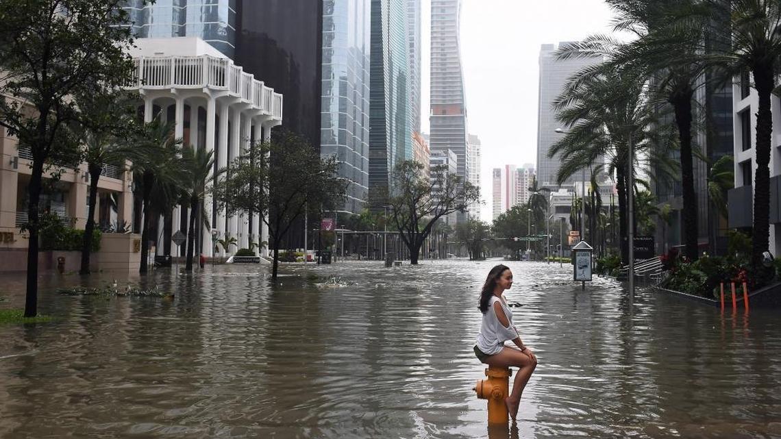 Mia Herman perches atop a fire hydrant after Hurricane Irma flooded Brickell Avenue in September. The National Hurricane Center recently concluded that rainfall and pour drainage caused flooding along parts of the street not adjacent to Biscayne Bay.