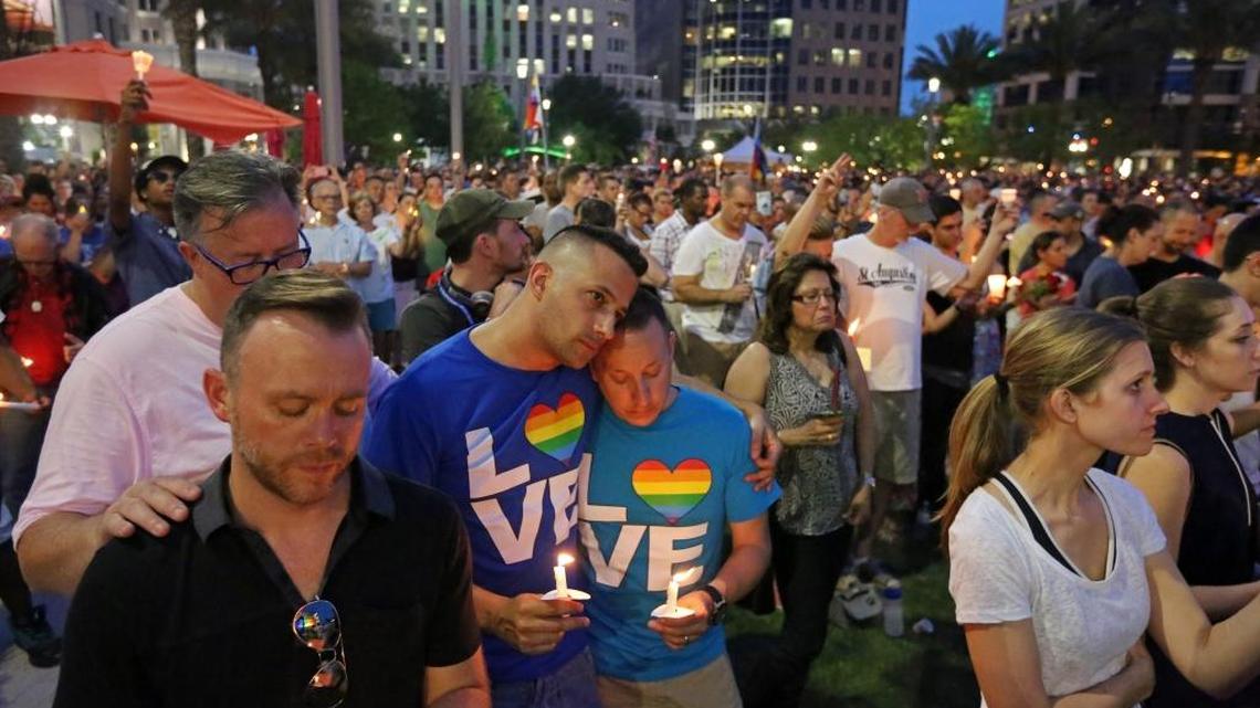 From L-R, Travis Morris, Paul Odom, Bobby Bongiorno and Eric Ferrari hold candles and observe a moment of silnce along with thousands of others who attended a vigil for the victims of the Pulse nightclub shooting. The vigil was on the lawn of the Dr. Phillips Center for the Performing Arts, Monday evening, June 13, 2016.