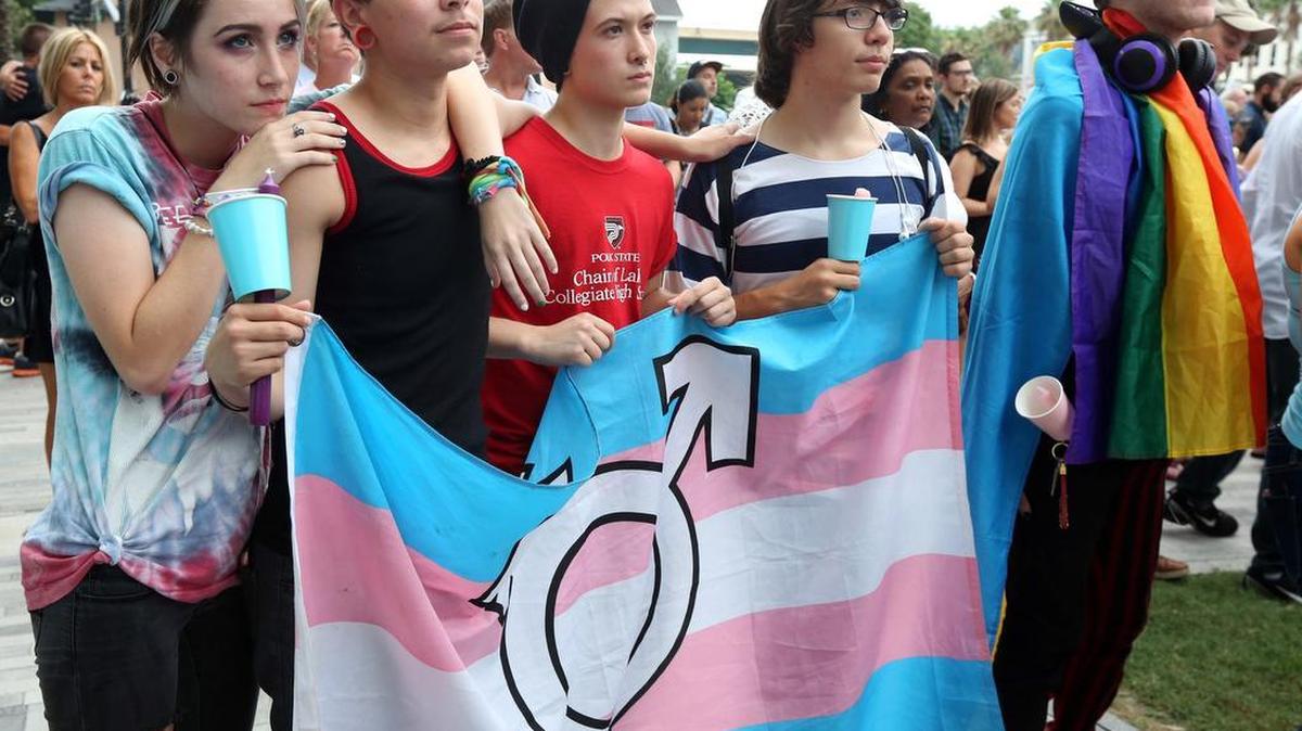 (From L-R) Madion Johnson, 19, Shane Young, 17, David Santiago-Tate, 16, Christina Rhothimir, 17, and Kyle Miesemer,19, all members of the Zebra coalition, an LGBT youth organization in Orlando attend a vigil for the victims of the Pulse nightclub shooting. The vigil was on the lawn of the Dr. Phillips Center for the Performing Arts, Mon., June 13, 2016.