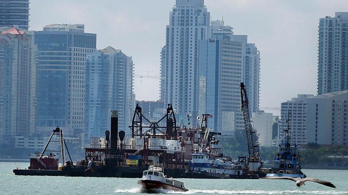 A dredging ship working on the Port of Miami Deep Dredge project is stationed in front of the Miami skyline as the deepening of the port's existing channels from its current 42-foot depth to 50-52-foot is been done in preparation for the Panama Cana Expansion to allow new larger cargo ships to enter the Port of Miami in March 2015.
