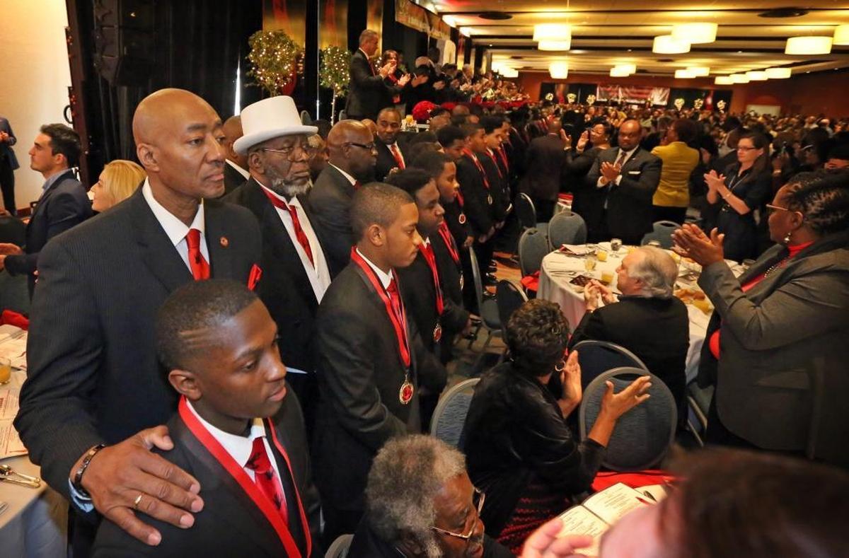 5000 Role Models of Excellence mentor, Arnold Montgomery, stands with graduating senior, Franky Augustine, as the young men are presented to the attendees of the 25th anniversary of the 5000 Role Models of Excellence Dr. Martin Luther King, Jr. Unity Scholarship Breakfast, Monday morning, Jan. 15, 2018.