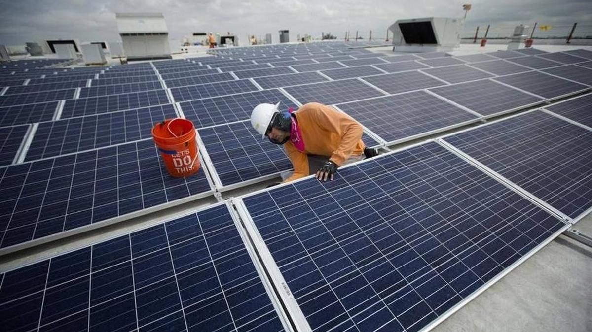 Neil Black works on the installation of South Florida’s largest solar panel array atop the IKEA store in Miami, Wednesday, April 16, 2014.