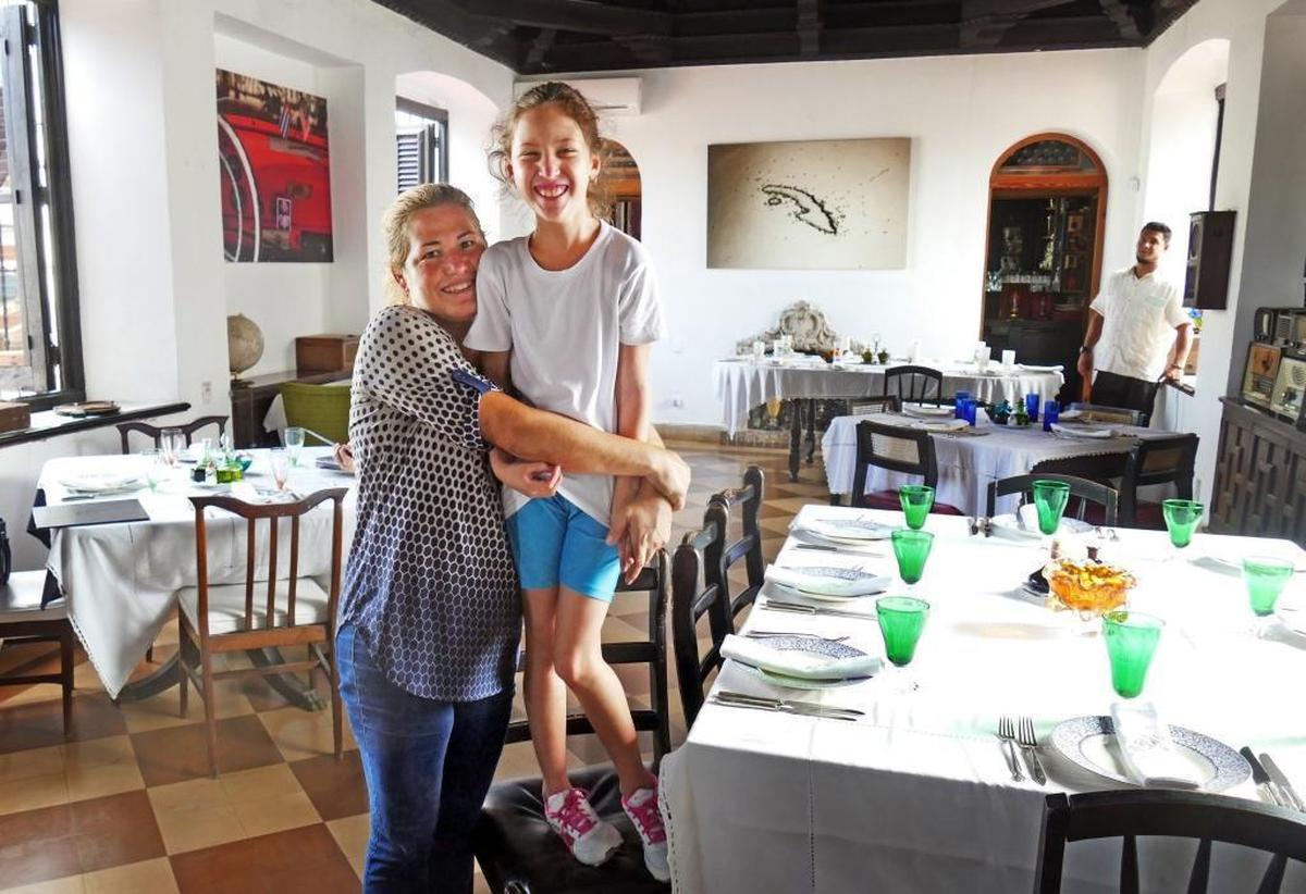 Niuris Higueras Martinez gives her daughter, Ysabella Cabeiro Higueras a big hug, Tuesday, Sept. 26, 2017 inside of their Havana restaurant Atelier.