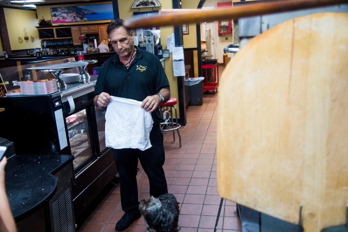 In this file photo, John D’Atria, owner of Cafe Amalfi, and his dog, Lakota, runs his restaurant as Hurricane Irma blows outside on Sunday, Sept. 10, 2017 in Bradenton. Cafe Amalfi remains one of the only open restaurants in Bradenton as the storm rages.