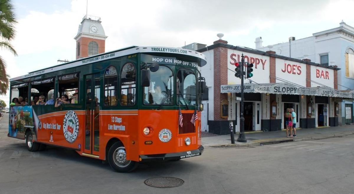 In this photo provided by the Florida Keys News Bureau, an Old Town Trolley, with cruise ship visitors aboard, passes Sloppy Joe’s Bar on Sunday, Sept. 24, 2017, in Key West. The arrival of Royal Caribbean’s Empress of the Seas was the first time a cruise ship has docked in Key West since Hurricane Irma.