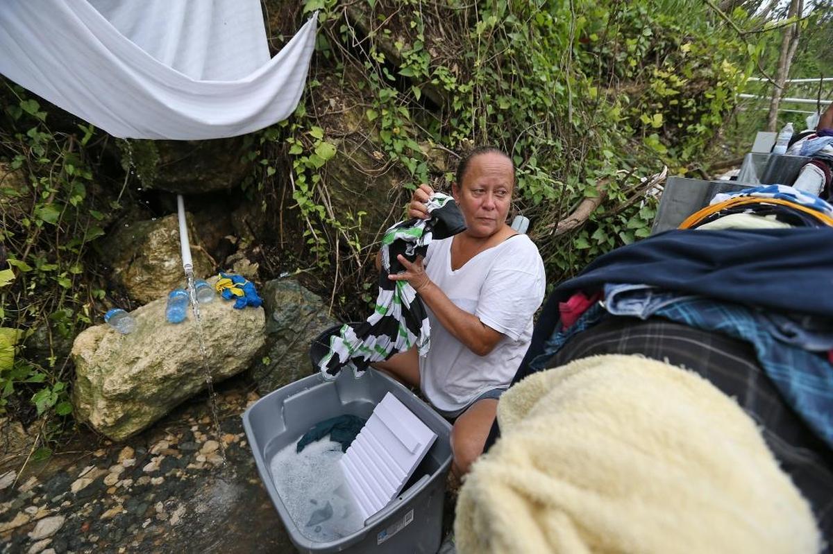 Utuado resident Maritza Collazo washes her clothes on the side of the highway in Utuado. Nearly six weeks after Hurriacne Maria, she still had no running water in her home.