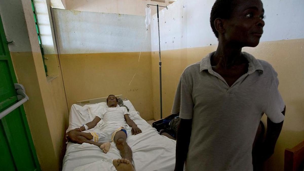 Arnold Dipo, 69, who was injured during Hurricane Matthew waits for medical help alongside his son at the Saint Antoine Hospital of Jérémie on Monday, October 10, 2016.