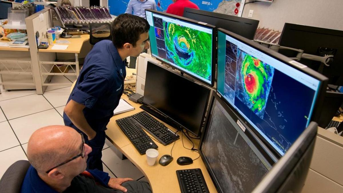 Senior Hurricane Specialist Lixion Avila, left, and Lt. Phil Manougian, a storm surge unit operations officer for the National Oceanic and Atmospheric Administration, watch radar and infrared satellite imagery depicting the eyewall of Hurricane Irma crossing the lower Florida Keys Sunday, Sept. 10, 2017, at the National Hurricane Center in Miami.