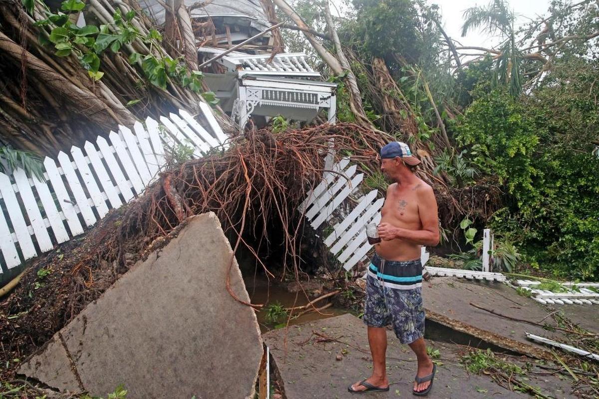 Robert Phillips looks at a house on Williams Street in Key West, crushed by a as Hurricane Irma passed over the island, September 10, 2017.