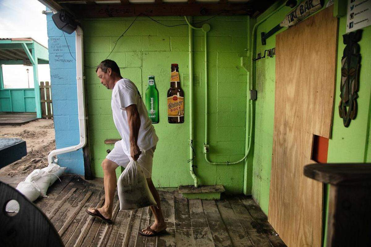 Acting Morehead City Mayor Richard Porter places sandbags around the Tackle Box Tavern bar in Atlantic Beach. The bar which boasts that it stays open 365 days per year closed its doors Wednesday.
