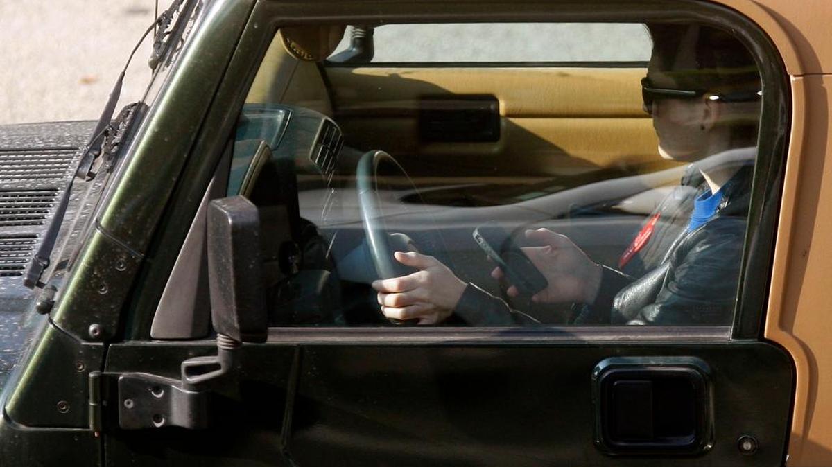 FILE- A driver uses an iPhone while driving Dec. 14, 2011, in Los Angeles.