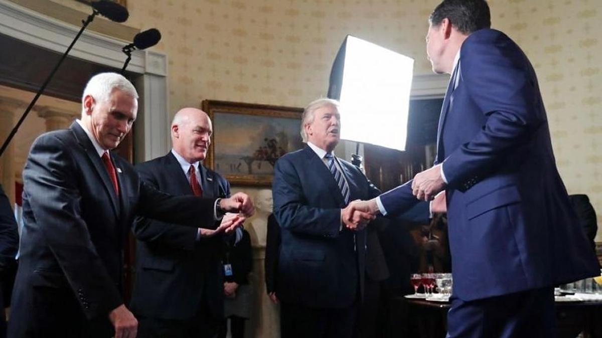 President Donald Trump shakes hands with FBI Director James Comey during a reception on Sunday, Jan. 22, 2017.