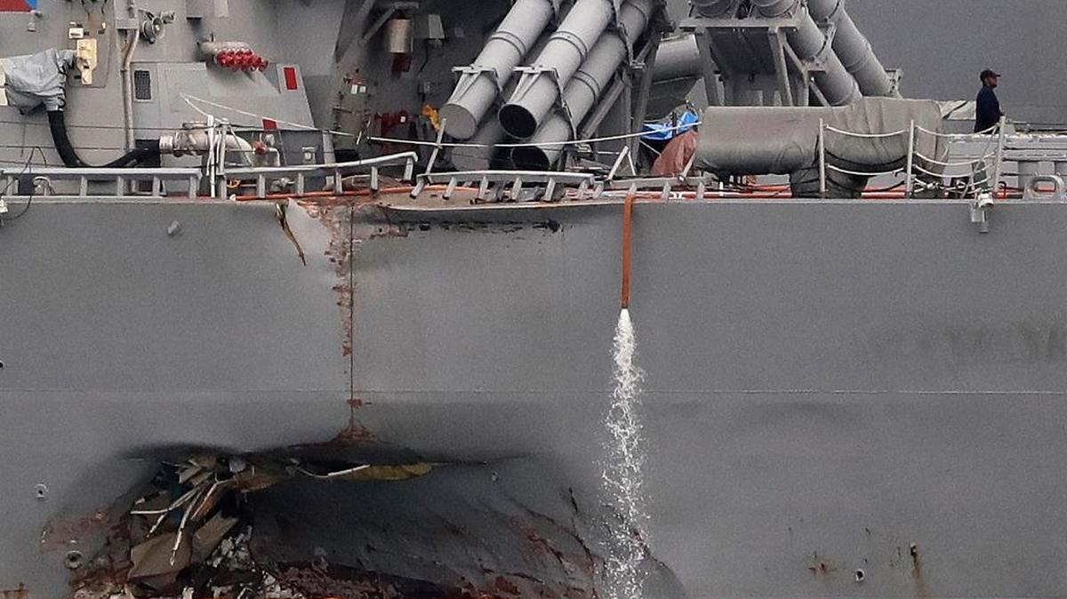 The damaged port aft hull of the USS John S. McCain, is visible while docked at Singapore's Changi naval base on Tuesday, Aug. 22, 2017 in Singapore.