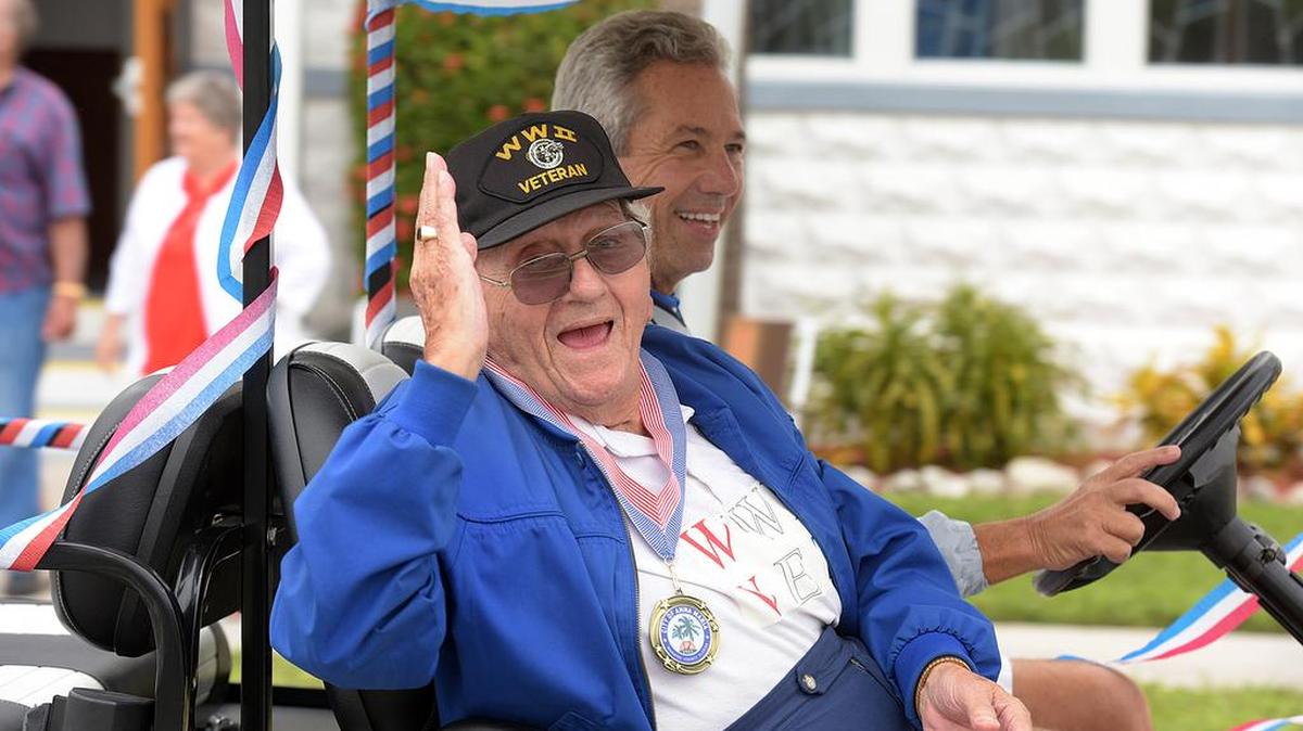 A World War II veteran waves to people during Anna Maria Island's "Old Soldiers and Sailors" parade Friday to honor Veterans Day.