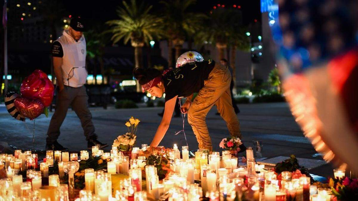 Priscilla Olivas lights a candle at a street vigil along the Las Vegas Strip on Monday.