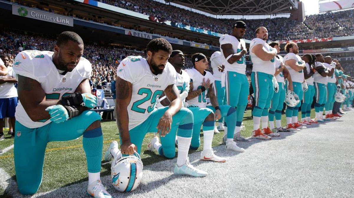 Miami Dolphins kneel during the singing of the national anthem before an NFL football game against the Seattle Seahawks, Sept. 11, 2016