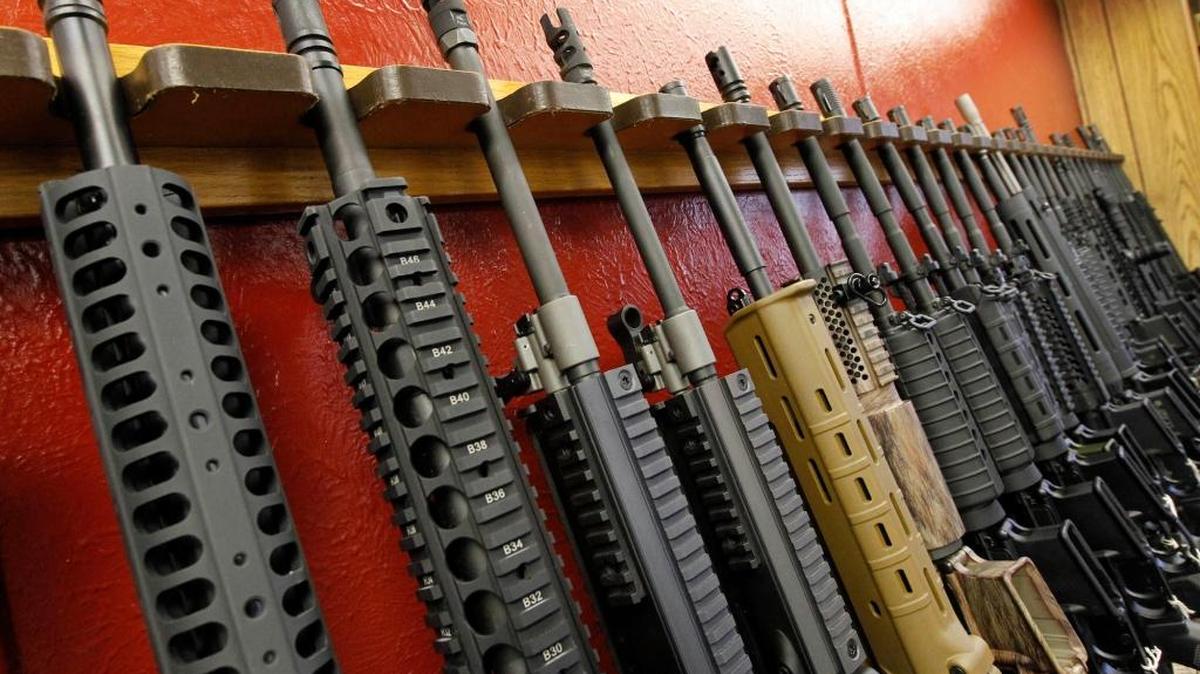 A row of different AR-15 style rifles are displayed for sale at an indoor range and gun shop, in Aurora, Colo. in 2012.