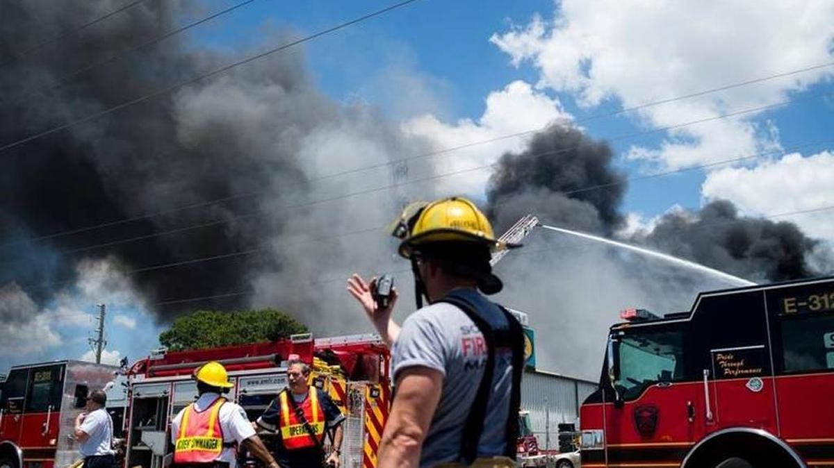 Firefighters and other emergency crews respond to the scene of a large fire at Callaghan Tire on May 18, 2017, in Bradenton. Smoke billowed high into the air with reported sightings as far as St. Petersburg.