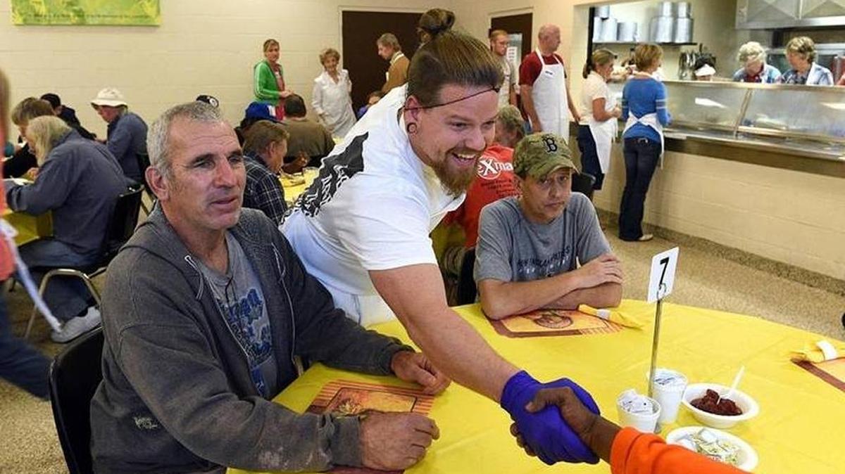 Volunteer Sean Roberts shakes hands Thanksgiving Day 2017 with a diner at the Salvation Army’s Thanksgiving meal.