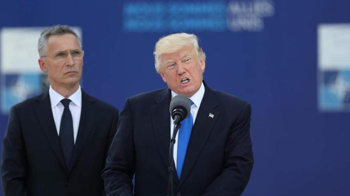 President Trump, speaks as Jens Stoltenberg, secretary general of NATO, looks on during a summit of world leaders in Brussels Thursday.