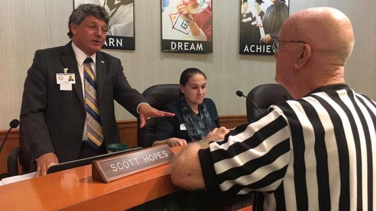 Manatee School Board Chairman Scott Hopes, left, talks to community activist Norm Nelson, right, during a December board meeting. At center is school board member Gina Messenger.